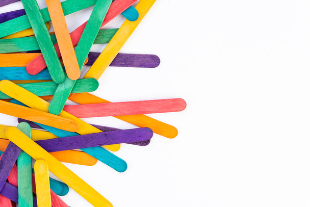 Popsicles en bois arc-en-ciel coloré sur fond de papier blanc avec espace de copie, bâtons de couleur abstraits cadre de couverture pour les enfants œuvres d'artisanat d'art, concept de retour à l'école pour les enfants - Photo, image