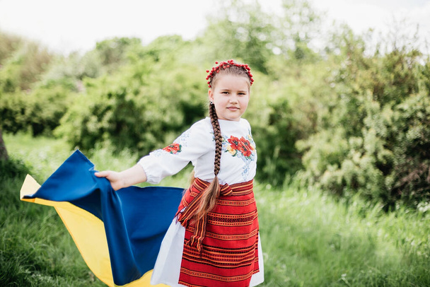 vyshyvanka day. Child in traditional embroidery with blue and yellow flag of Ukraine. Ukraines Constitution day. 24 August. Patriotic holiday. outdoor portrait of girl. Ukraine's Independence Day. - Fotografie, Obrázek