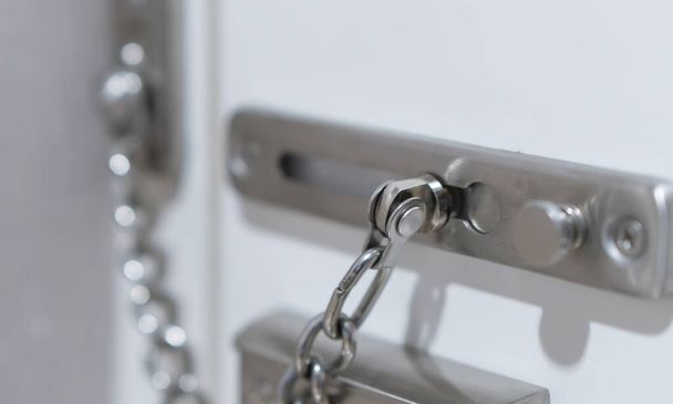 Metalen deur ketting slot in hotelkamer, veiligheid bescherming bij reizen naar het buitenland - Foto, afbeelding