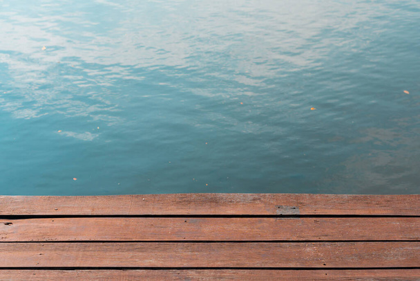 fond de surface d'eau bleue avec plate-forme de planche en bois de quai dans le parc, espace de copie de rivière vide pour la conception - Photo, image