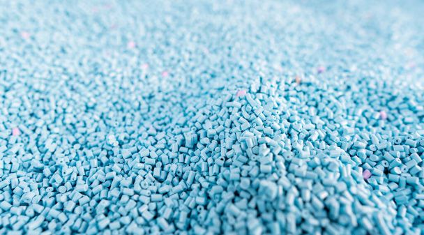 Close up large pile of blue plastic granules in temporary storage of production line at recycle factory, masterbatch dye polymer plastics resin pellet background,  injection molding process lab - Photo, Image