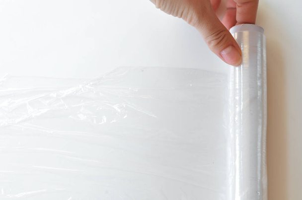 Πλαστική λεπτή και διάφανη μεμβράνη σε λευκό φόντο  - Φωτογραφία, εικόνα