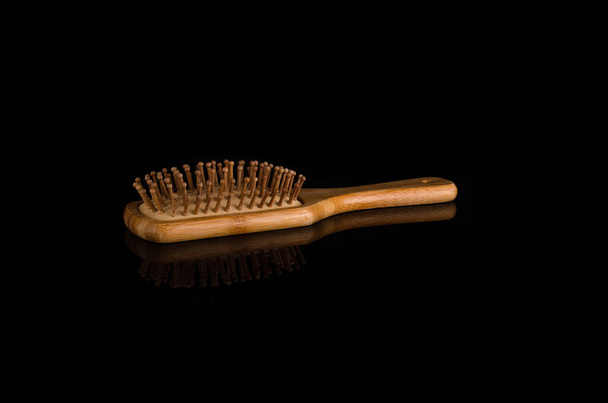 Peine peluquero de madera sobre fondo negro - Foto, Imagen