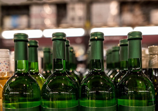 пляшки вина на полицях у великому магазині
  - Фото, зображення
