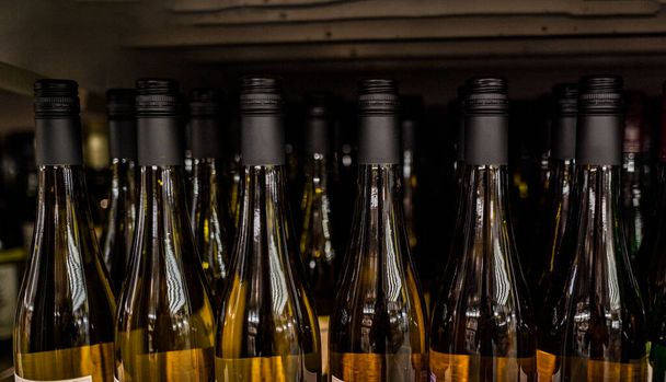 Weinflaschen stehen in einem großen Geschäft in den Regalen  - Foto, Bild