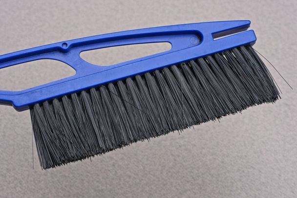 uma grande escova de plástico azul varre a poeira da parede cinza - Foto, Imagem