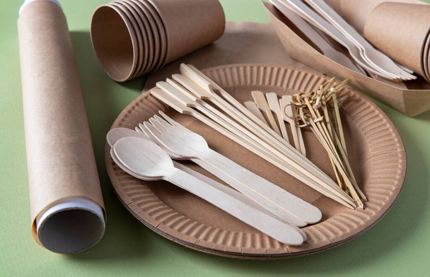 Disposable biodegradable tableware on craft paper plate - forks, spoons, glasses, bamboo skewers and parchment. Zero Waste. - Photo, Image