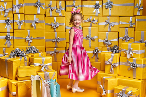 Portrait of happy child girl dancing having fun, in room full of present boxes - Foto, Bild