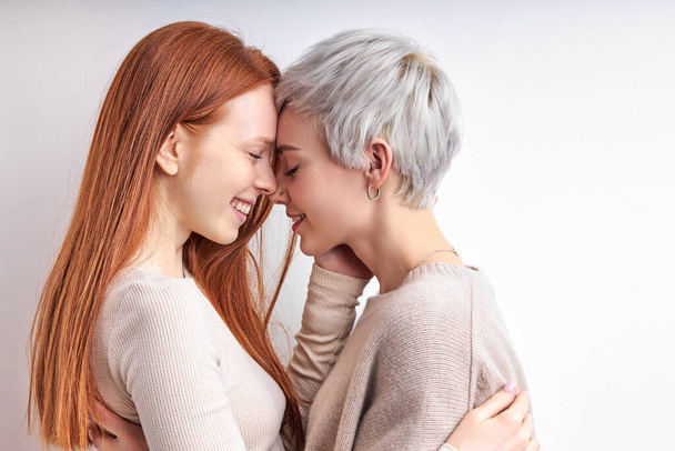 Side View Portrait Of Awesome Redhead Woman And Short Haired Lady Hugging, Feeling Love - Foto, immagini
