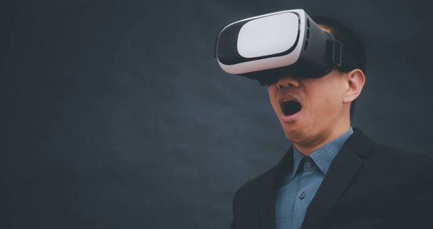 Zakenman draagt virtual reality bril VR en touch in grafiek Scherm van een mediascherm op de donkere achtergrond, Technology Process System Business, succes en teamwork concept - Foto, afbeelding