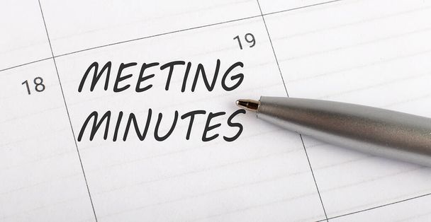 Texto MEETING MINUTES en planificador de calendario para recordarle una cita importante con pluma sobre fondo blanco aislado. - Foto, imagen