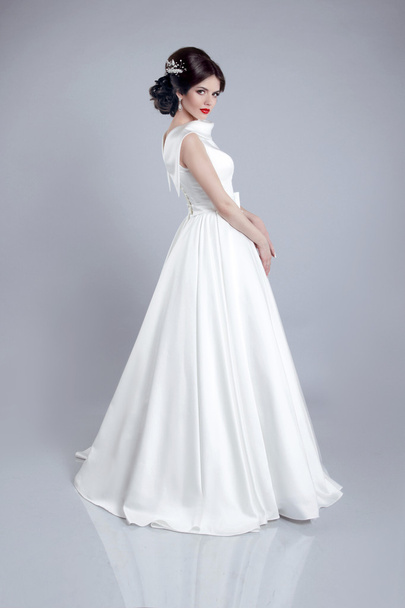 Fashionable bride model in wedding dress isolated on gray backgr - Valokuva, kuva
