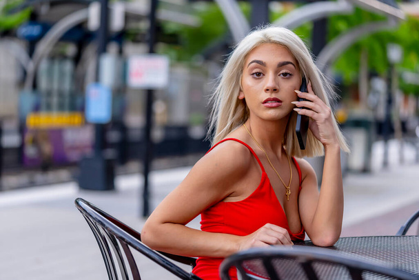 A gorgeous blonde model poses outdoors in an urban environment - Фото, изображение