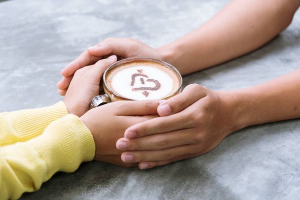 Koncepcja miłośnika kawy. Zamknij kobiece dłonie trzymając filiżankę kawy. Picie kawy sprawia, że ludzie są świeży i bardziej skoncentrowani na pracy. zima potrzeba gorącej kawy jest najlepszym wyborem. - Zdjęcie, obraz