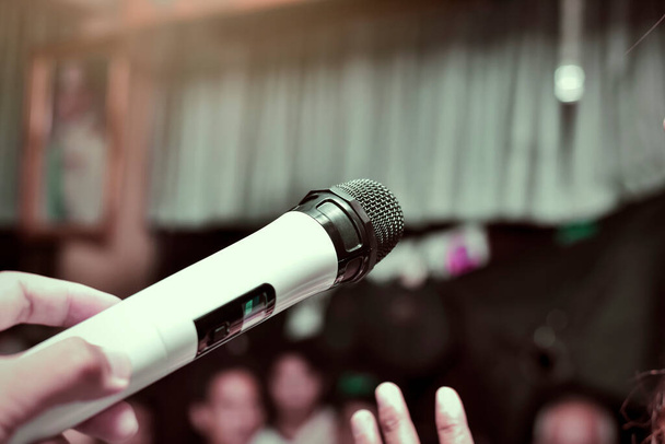 Im selektiven Fokus des Mikrofons über dem abstrakten unscharfen Foto des Audience Meeting Seminars im Hintergrund des Konferenzsaals. - Foto, Bild