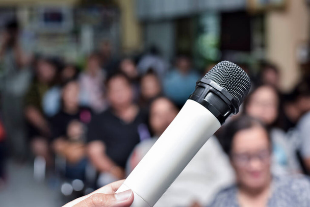 Im selektiven Fokus des Mikrofons über dem abstrakten unscharfen Foto des Audience Meeting Seminars im Hintergrund des Konferenzsaals. - Foto, Bild