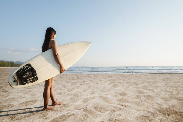 Όμορφη σέξι surfer θηλυκό με σανίδα του σερφ στην αμμώδη παραλία. Θαλάσσια σπορ. Surfing είναι υγιής ενεργό τρόπο ζωής. Θερινές διακοπές. - Φωτογραφία, εικόνα