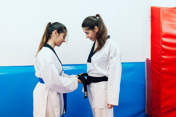 Dvě mladé ženy se oblékají do svého taekwondo kimona - Fotografie, Obrázek