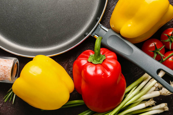 Clean frying pan with products on dark background - Photo, Image