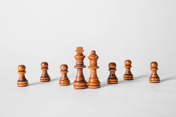 Chess pieces on light background - Фото, изображение