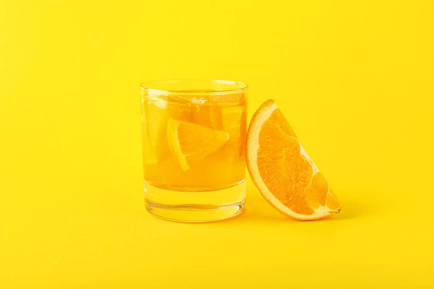 Glass of tasty orange jelly on color background - 写真・画像