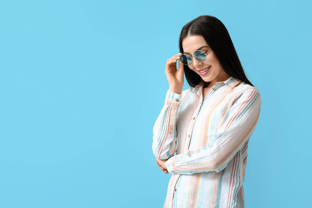 Beautiful young woman wearing stylish sunglasses on color background - Photo, Image