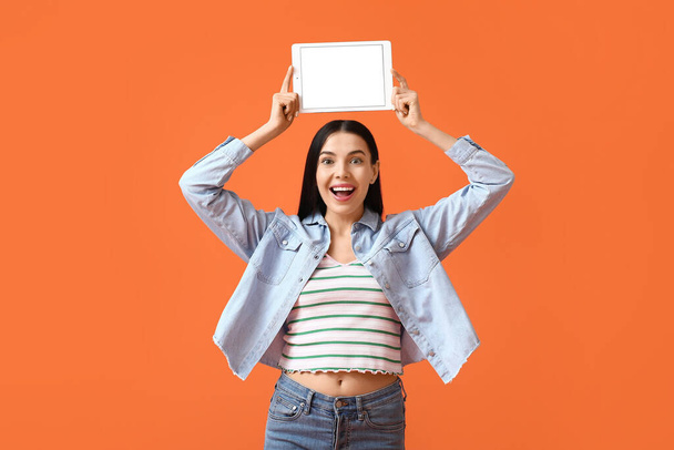 Happy young woman with tablet computer on color background - Foto, Bild