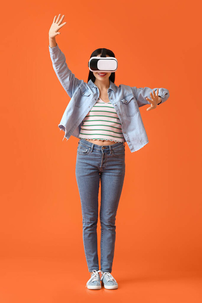 Young woman with VR glasses on color background - Foto, Imagem