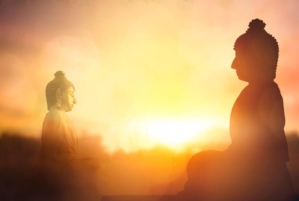 Koncepcja Vesak Day: Sylwetka Buddy na złotym tle zachodu słońca - Zdjęcie, obraz