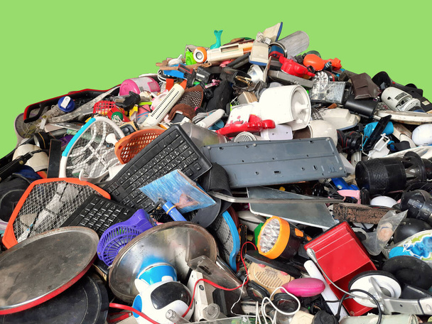 Pile de déchets électroniques et ménagers usagés Division des déchets cassés ou endommagés avec fond vert, E-déchets pour la réutilisation et le recyclage et est un problème avec le concept de l'environnement. - Photo, image