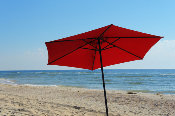 Strandparasol op een zonnige dag, zee op achtergrond - Foto, afbeelding