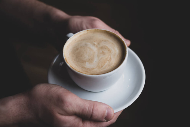 White cappuccino cup in the hands of a man - Foto, afbeelding
