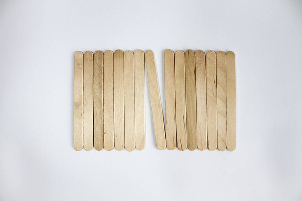 Рядок дерев'яних паличок ізольовано на білому тлі
. - Фото, зображення