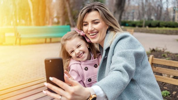 Happy mom and daughter taking selfie outdoors - Foto, afbeelding