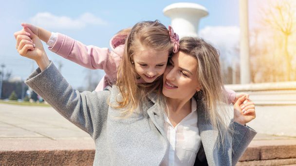 Счастливая мама с дочерью позируют на открытом воздухе - Фото, изображение