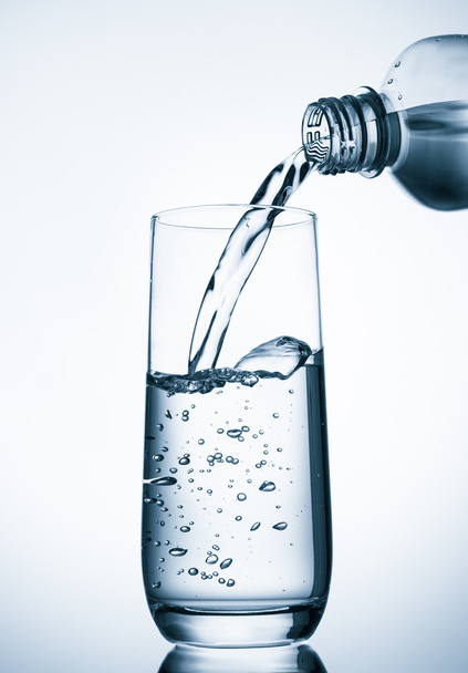 Pouring water into glass  from bottle - Photo, Image