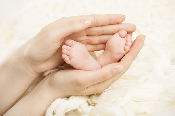 Newborn baby feet mother holding in hands. New born and parent - Photo, Image