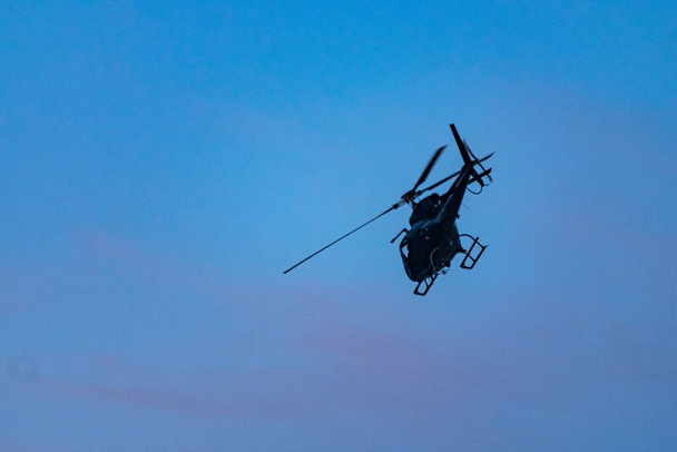 Helicóptero que brinda apoyo aéreo durante una operación de la Policía Civil para combatir el crimen organizado y el narcotráfico, en una comunidad (favela) en Río de Janeiro, Brasil. - Foto, Imagen