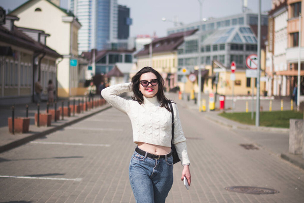 lifestyle fashion portrait of young stylish hipster woman walking on the street - Photo, image