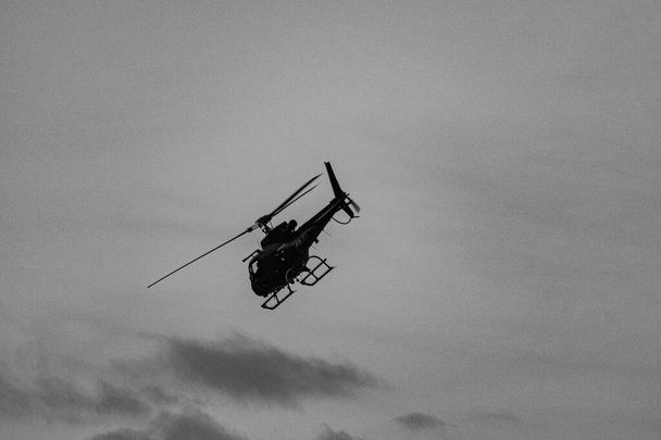 Вертолет, обеспечивающий поддержку с воздуха во время операции гражданской полиции по борьбе с организованной преступностью и незаконным оборотом наркотиков, в общине (Фавела) в Рио-де-Жанейро, Бразилия. - Фото, изображение