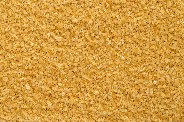 Brown demerara sugar, background, from above. Coarse, crystalline, natural and raw sugar, a sucrose sugar with distinctive yellow-brown color, due to presence of molasses. Backdrop. Macro, food photo. - Photo, Image