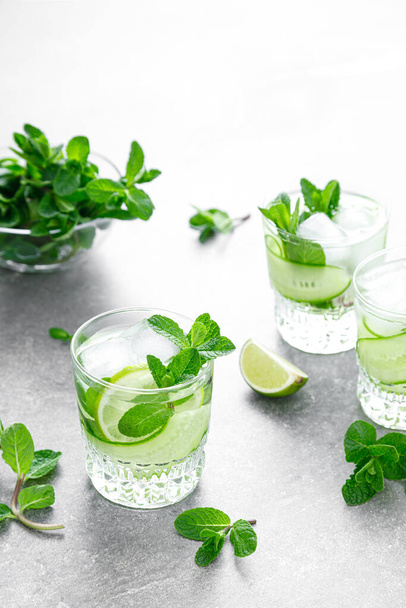 Mint, lime and cucumber refreshing infused detox cocktail with ice, light refreshment summer mocktail - Foto, Imagen