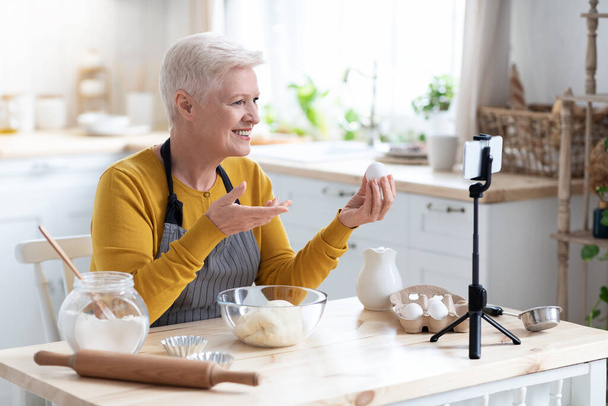 Yaşlı kadın yemek blogcusu onun yemeklerini akıllı telefondan kaydediyor. - Fotoğraf, Görsel