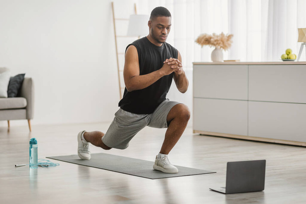 Black Guy Doing Forward Lunge Exercise At Laptop At Home - Photo, Image