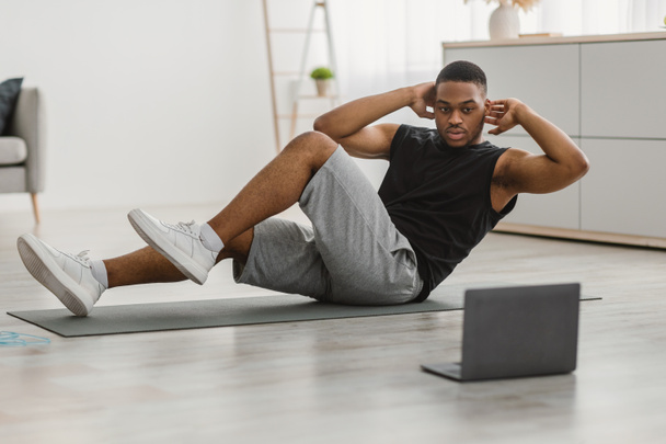 African Guy Doing Elbow To Knee Abs Crunches At Home - Photo, Image