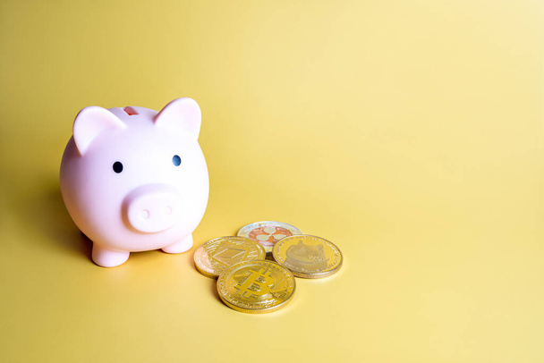 Piggy bank naast populaire crypto munten op gele achtergrond met kopieerruimte. Bitcoin, Ripple XRP, Dogecoin en Ethereum. Investeringen, sparen, vasthouden, kopen cryptogeld concept. - Foto, afbeelding