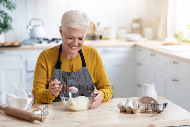 La nonna allegra che fa la pasta a cucina, copia lo spazio - Foto, immagini