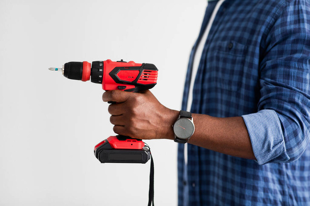 African american driller man with electric screwdriver, ready to repair home furniture, white background, side view - Φωτογραφία, εικόνα
