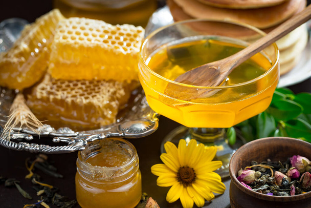 Sweet honey with flowers on an old background. - Photo, Image