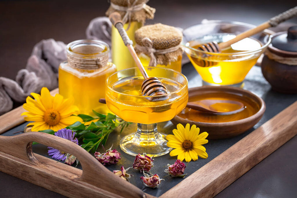 Sweet honey with flowers on an old background. - Photo, Image